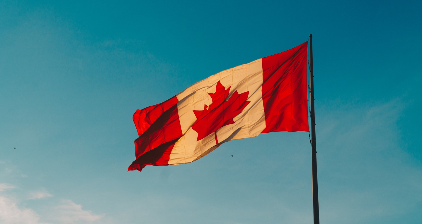 Canadian flag waving against a blue sky